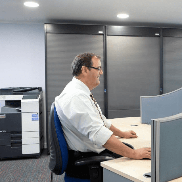 A Silktrim employee sitting at an office cubicle.